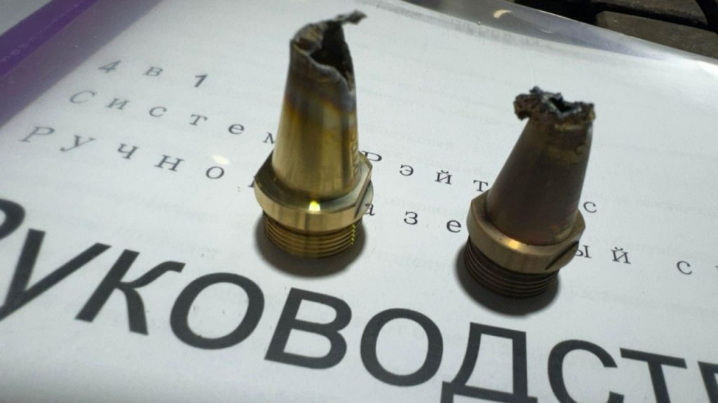 lose-up view of a severely melted fiber laser welding nozzle tip showing heat damage, deformation, and blockage. One typical example of backreflection failure.